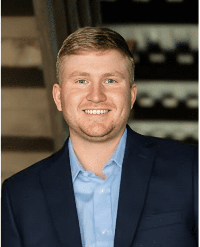 Smiling man in blue suit jacket.